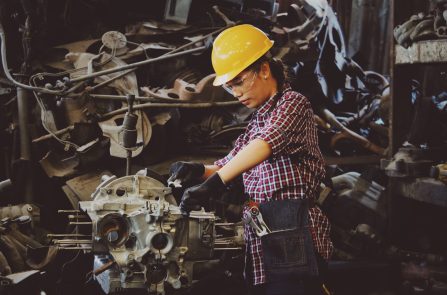 woman-wears-yellow-hard-hat-holding-vehicle-part-1108101