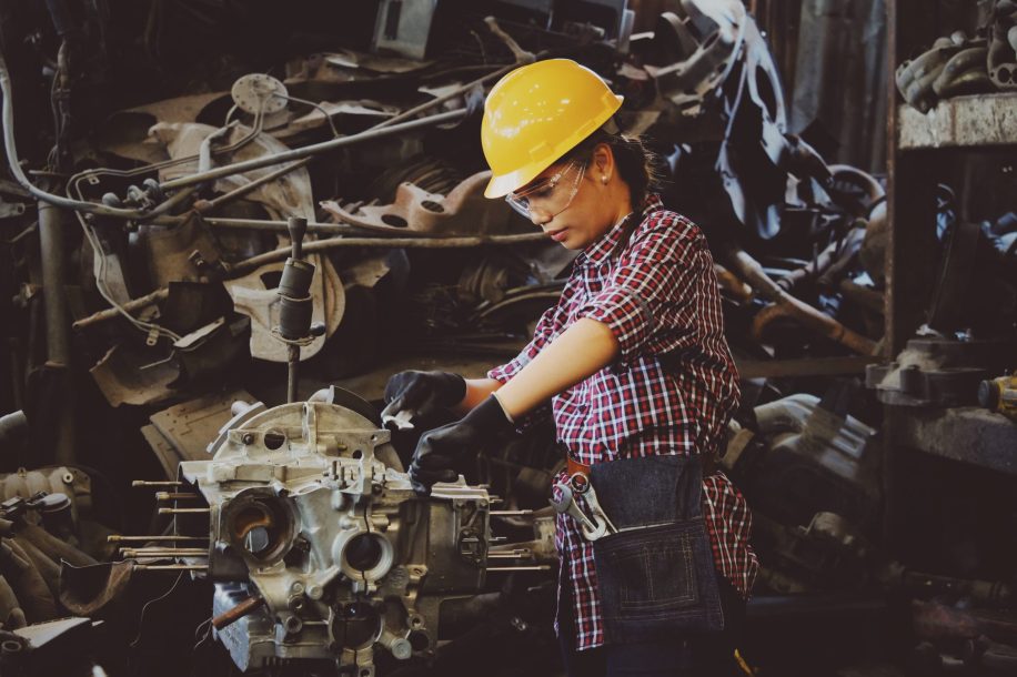woman-wears-yellow-hard-hat-holding-vehicle-part-1108101